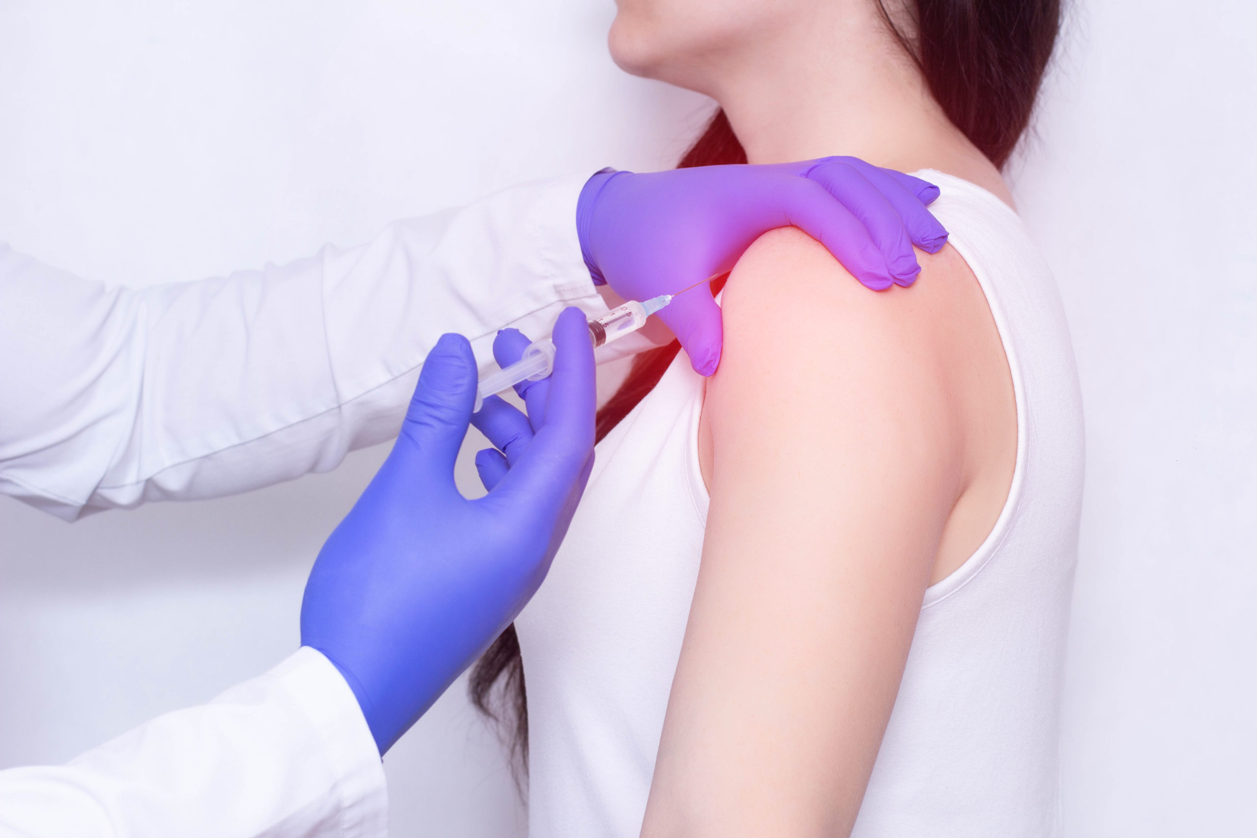 Doctor makes an injection of ozone in the girl's sore shoulder.