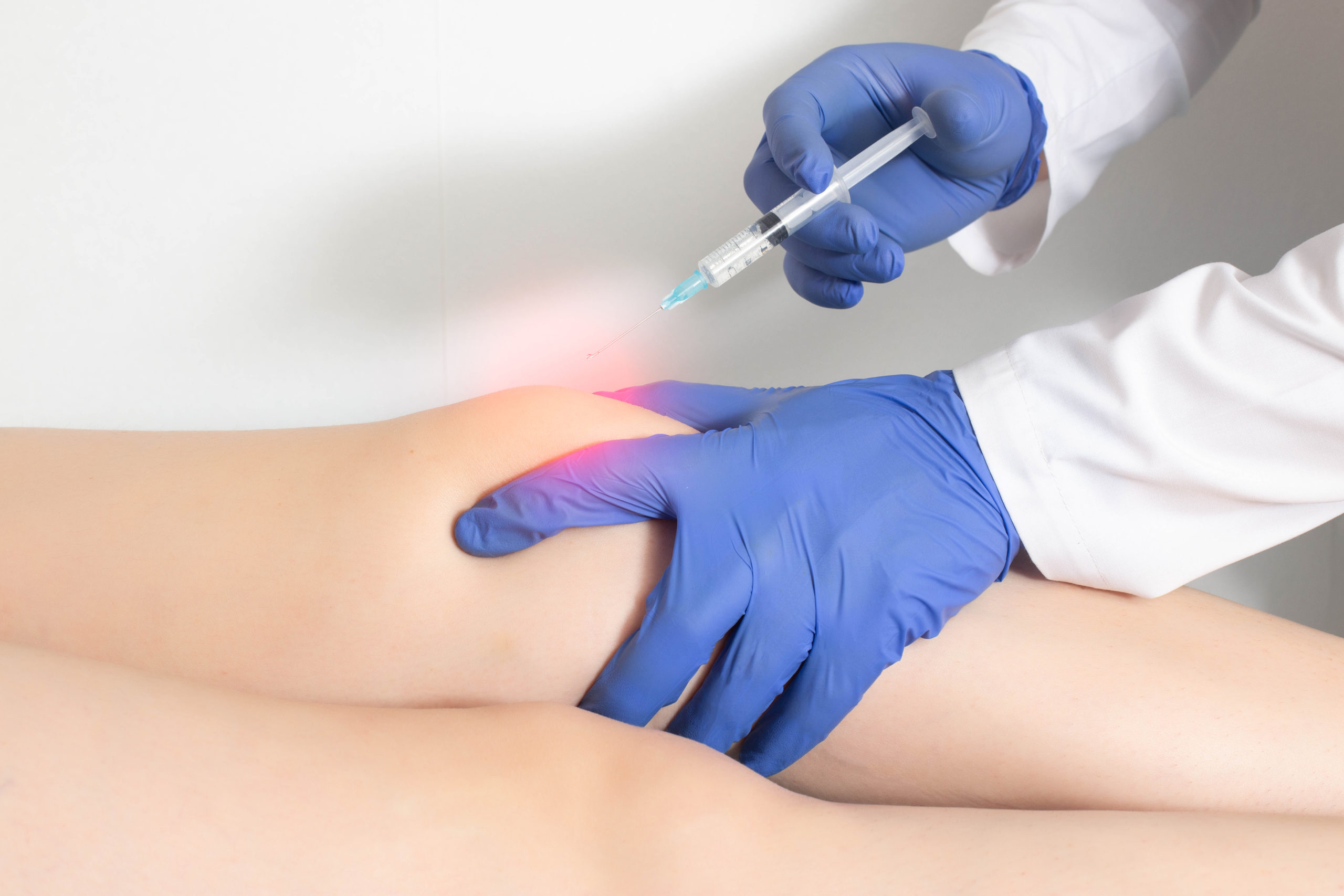 The doctor injects an ozone-oxygen mixture into the patient's knee joint to relieve muscle spasm and inflammation.